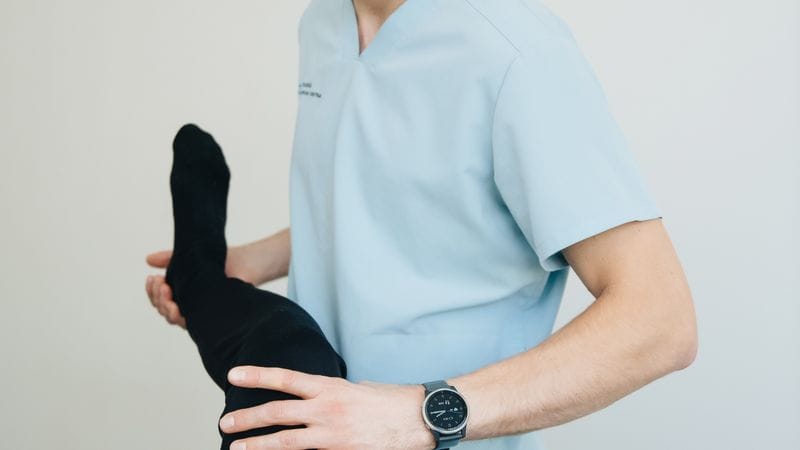 Physiotherapist guiding knee friendly leg exercises to help fix squat knee pain safely