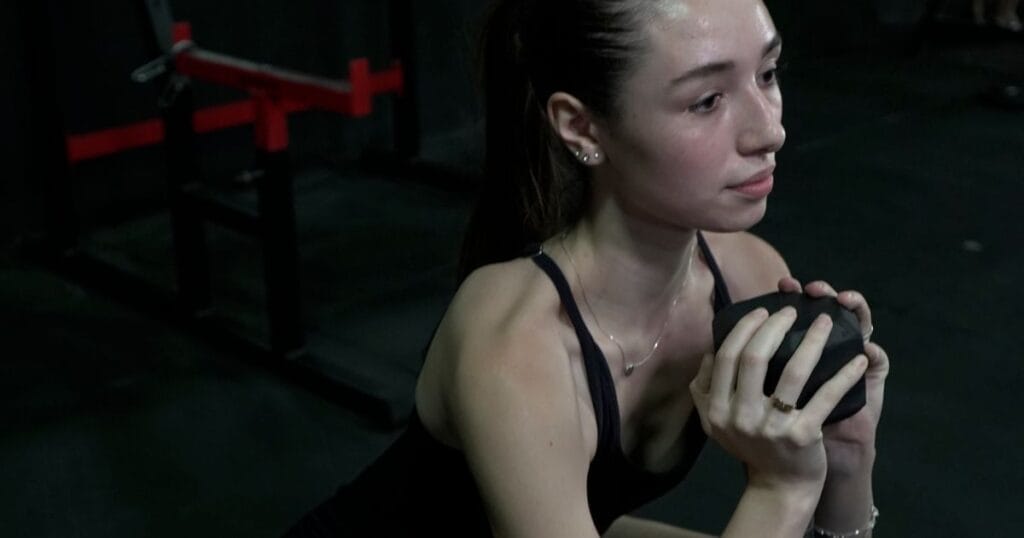 Athlete performing a controlled squat in the gym while learning safe squat technique for knee pain during squats