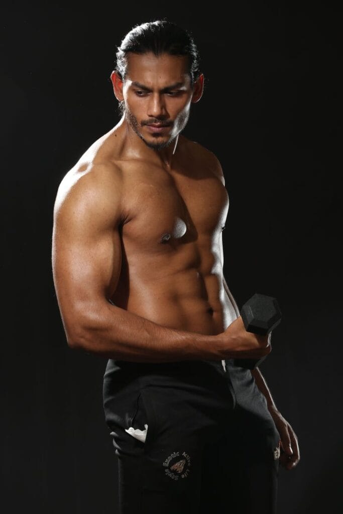 Home Workout Routinestrength by lifting a dumbbell during a studio photoshoot.