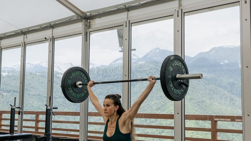 	How to stay tight in squat: athlete reviewing the beginner squat bracing checklist and workout notes after a session