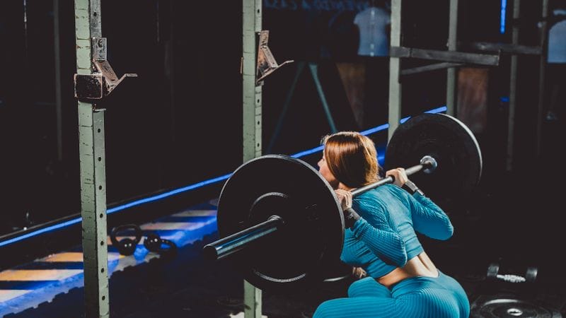 Breathing while squatting beginner: goblet squat setup showing proper core bracing and stacked torso position for safe squatting